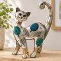 Gato decorativo plateado sobre repisa de madera