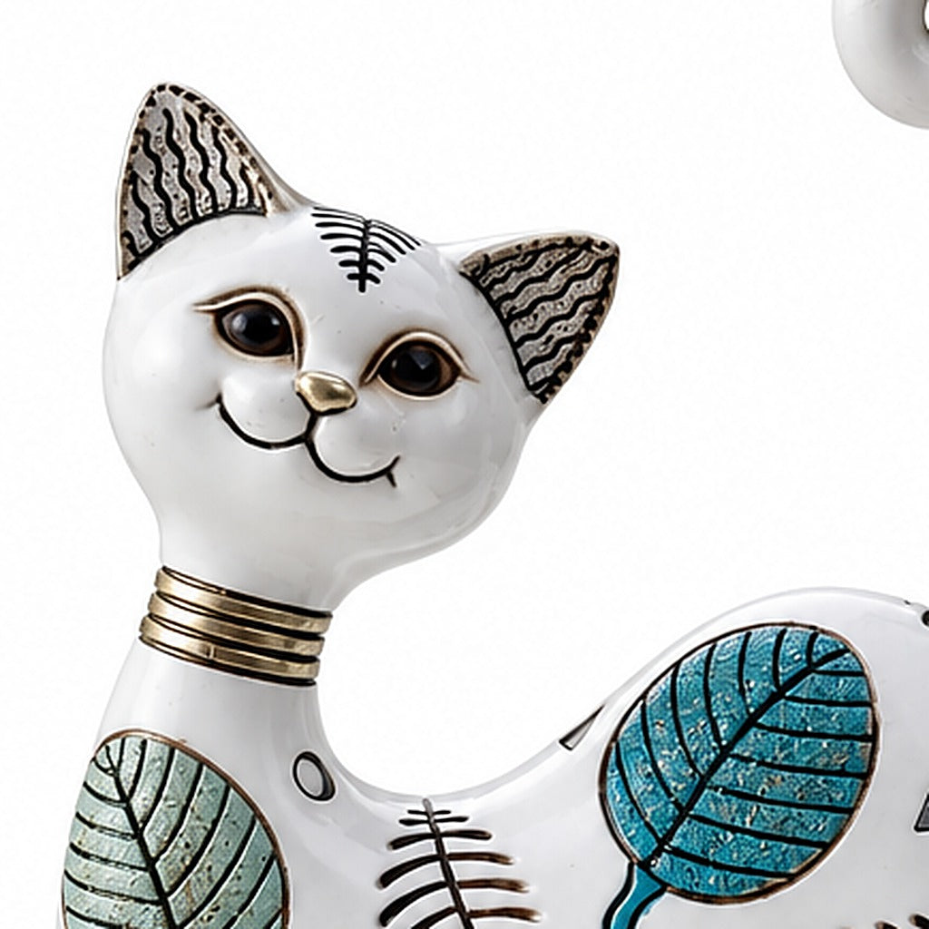 Gato decorativo blanco, detalle del rostro y las hojas